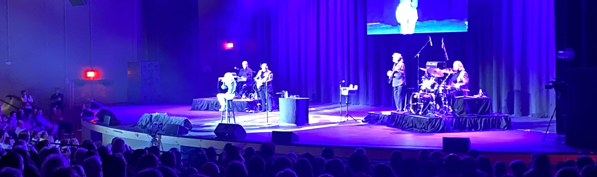 signer on stage in chair washed out by the lights San Diego